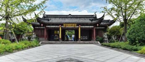 Una puerta tradicional china con un emblema circular en el centro, rodeada por un patio empedrado.