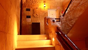 A staircase with stone walls and a handrail, leading to a door at the top. - Hotel Donia (Hammam Chatt)
