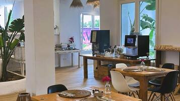 Un interior moderno con vigas de madera, un comedor con mesa y sillas de madera, y una cocina con un ventanal grande.