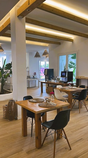 A modern interior with wooden beams, a dining area with a wooden table and chairs, and a kitchen area with a large window. - WaWa Tarifa (Tarifa)