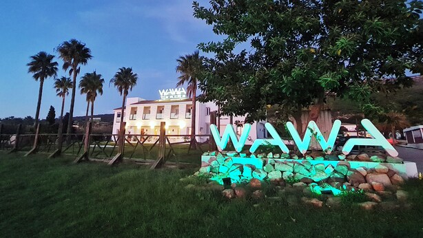 A hotel with a signboard and palm trees in the foreground. - WaWa Tarifa (Tarifa)
