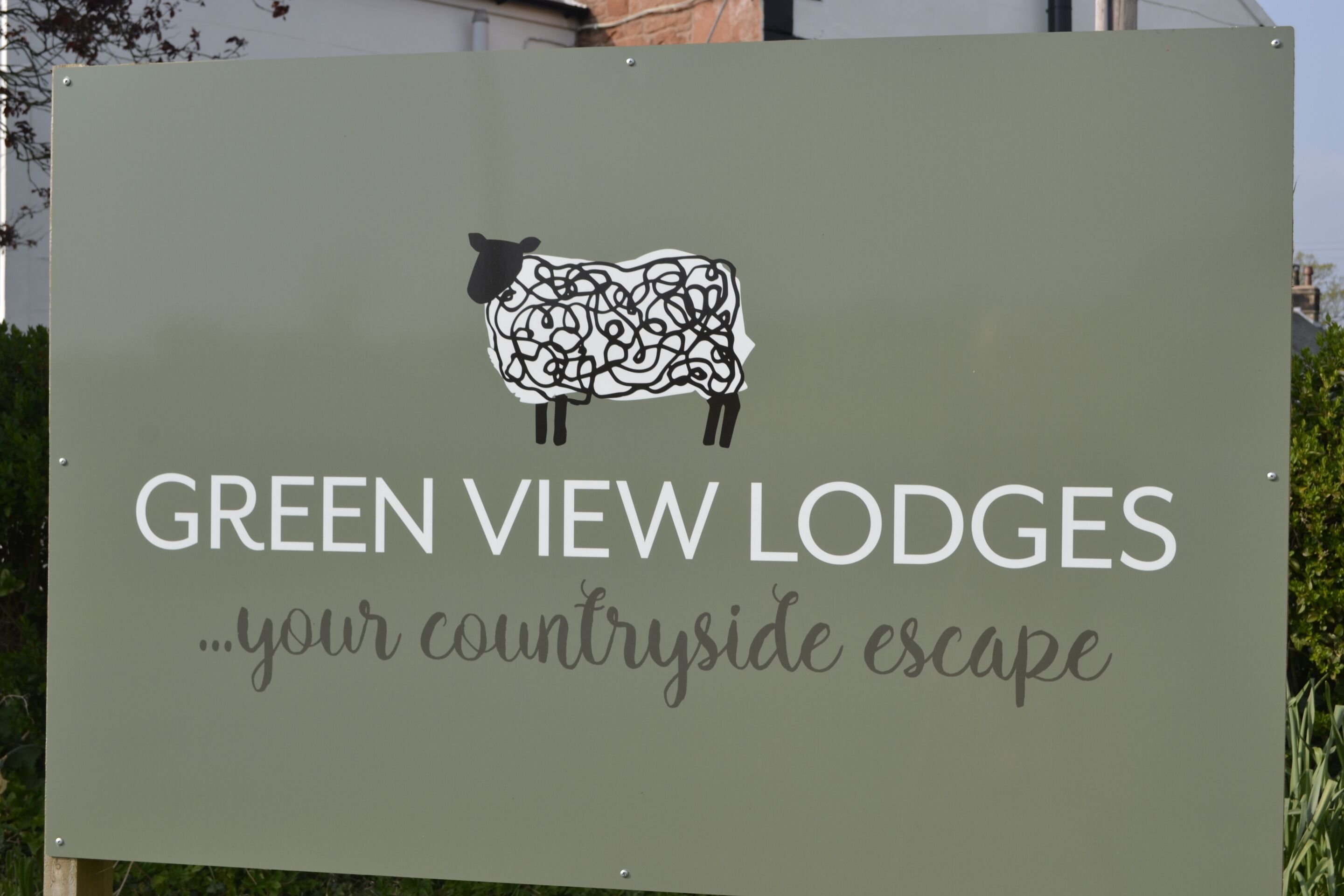 A sign for Green View Lodges advertising a countryside escape.