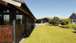 Un bâtiment à l’extérieur en bois et doté d’une pelouse bien entretenue.