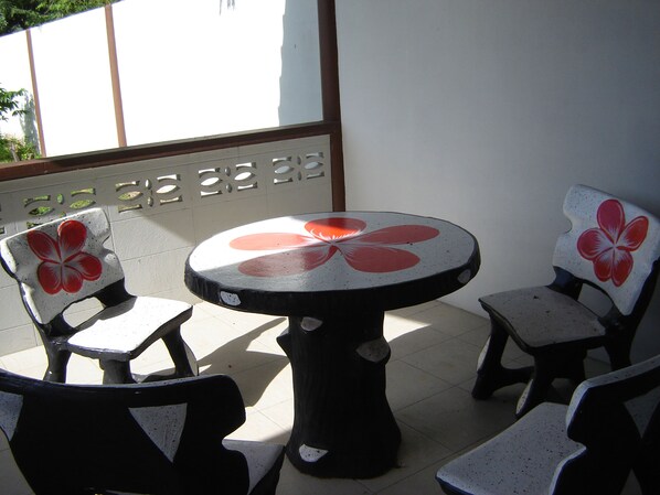 A round table with a flower design, surrounded by four chairs with similar floral patterns. - Banlang Hotel Resort & Swimmingpool (Tha Tum)