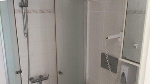 A bathroom with a glass-enclosed shower, a toilet, a sink, and a mirror. - Cohiba Hotel (Bodrum)