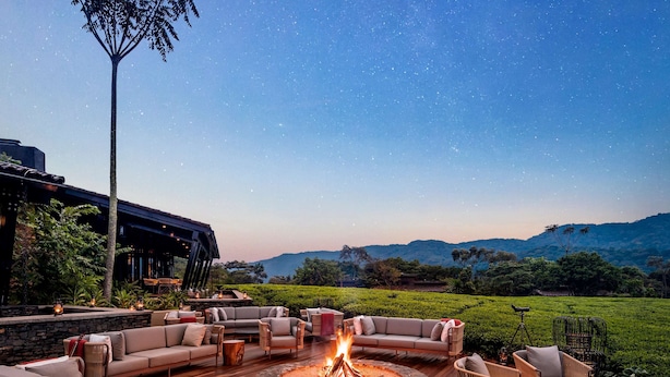 A starry night sky, outdoor seating area with fire pit, and a view of distant hills. - One&Only Nyungwe House (Bushekeri)