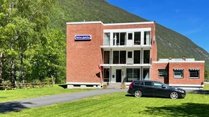A two-story brick building with a sign reading "Ryazan plechkov". - Rjukan Gjestehus (Tinn)