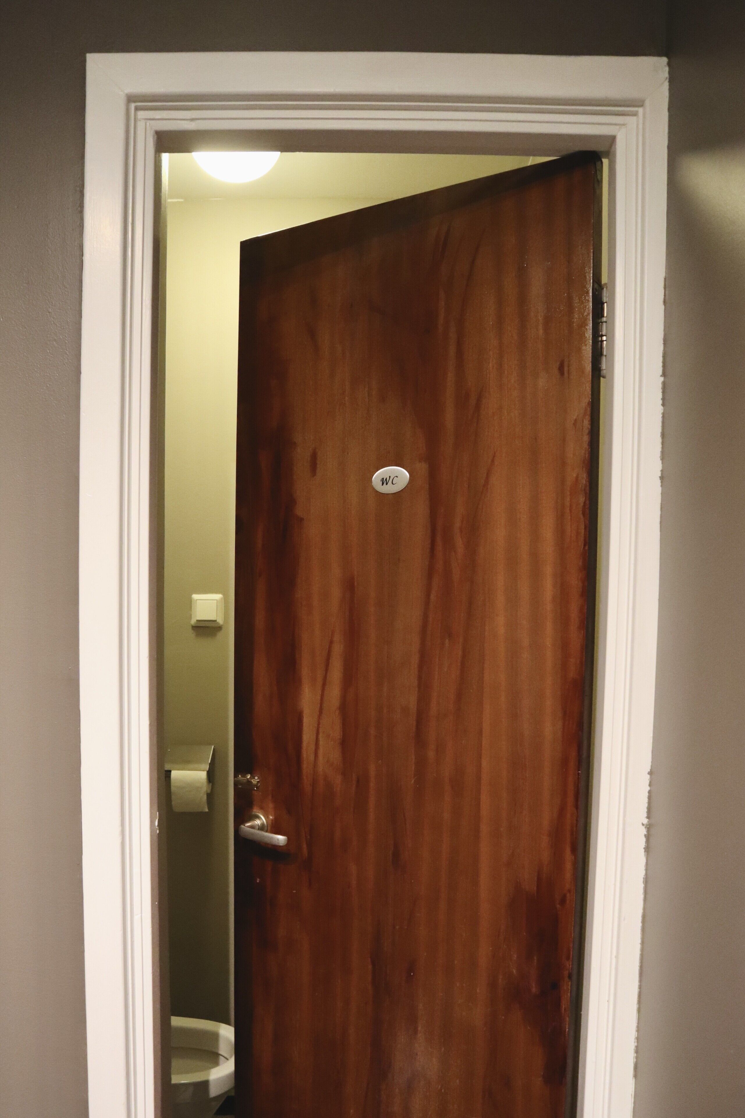 Puerta de madera con un letrero que indica 'WC', señalando un baño.