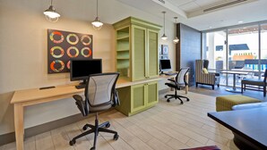 Un espace de bureau moderne, doté de bureaux, de chaises et d’une grande fenêtre.