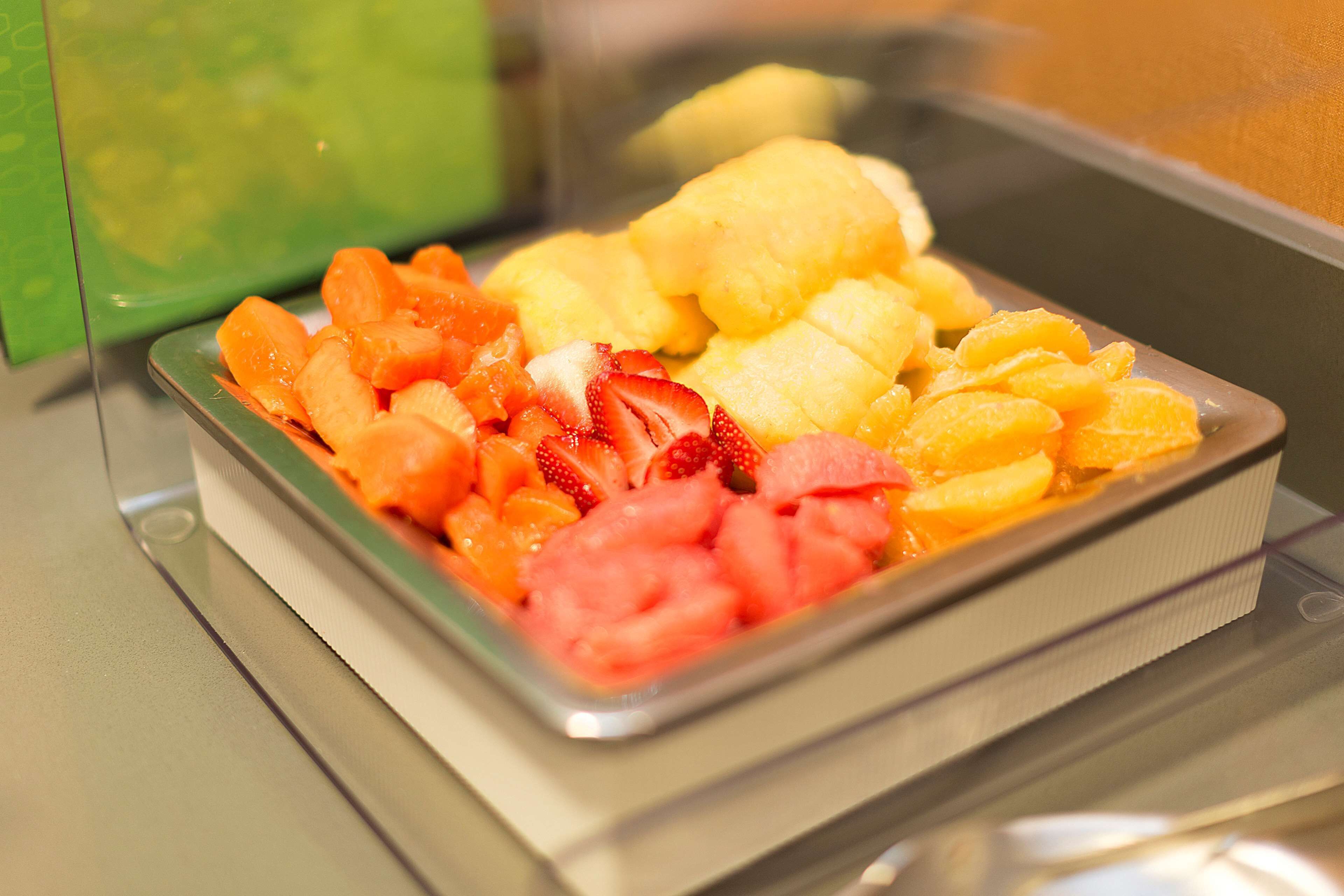 A tray of assorted fruits including strawberries, watermelon, and oranges.