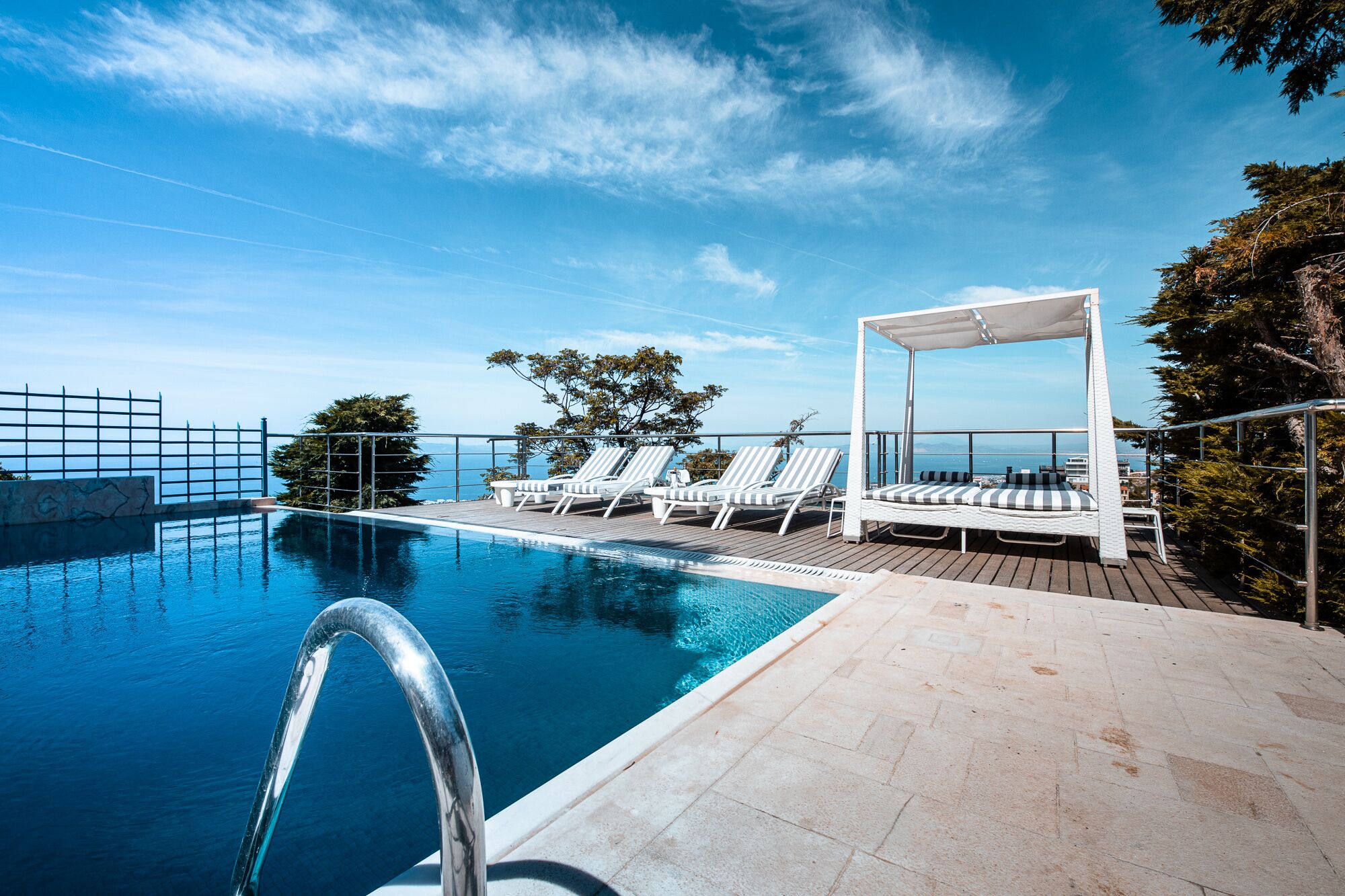 Alberca al aire libre, sombrillas en la alberca y camastros 