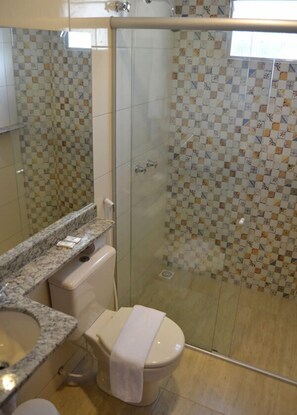 Chuveiro, secador de cabelo, toalhas de banho, papel higiênico