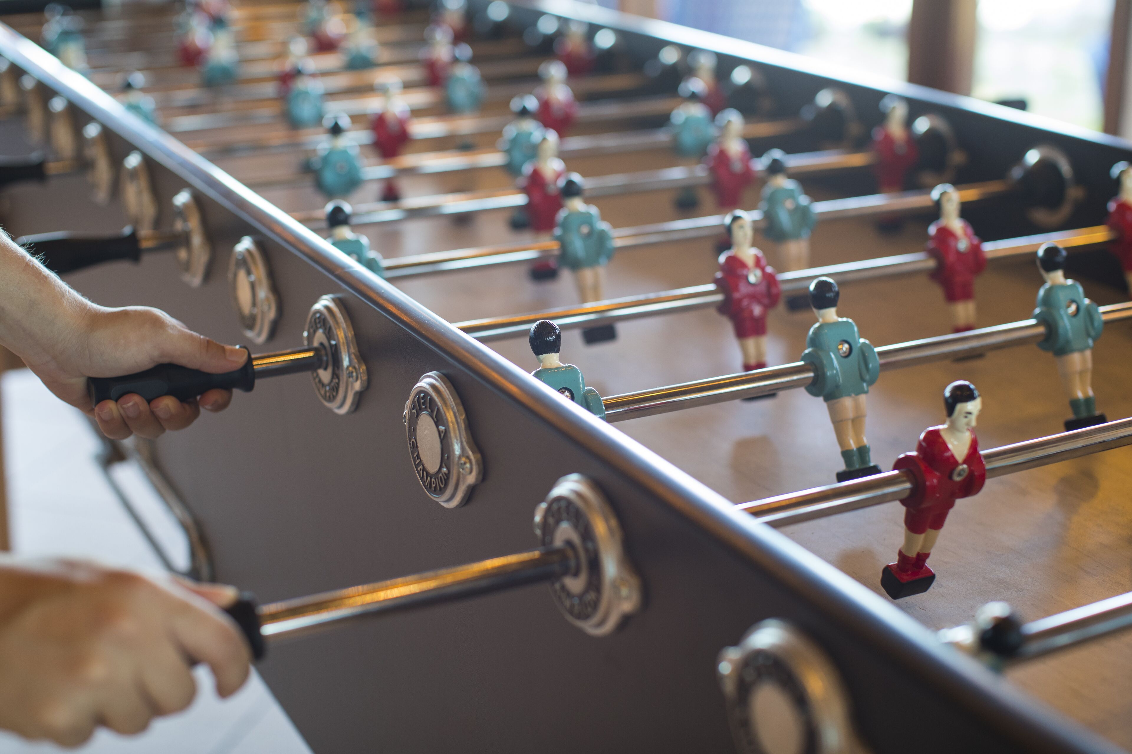 A foosball table with players in red and blue uniforms.