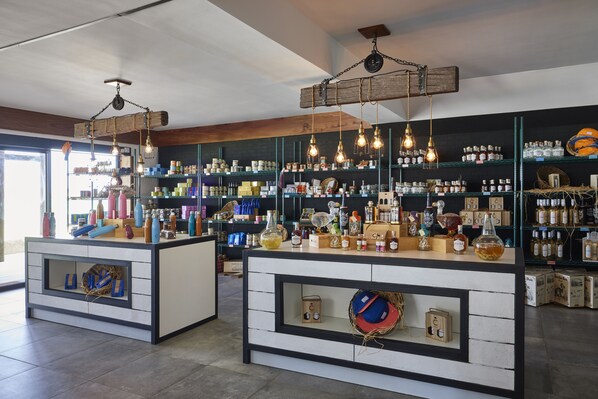 Un espace bar doté de deux comptoirs, d’étagères remplies de bouteilles et de luminaires suspendus.