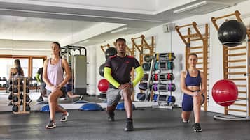 Un gimnasio con equipo de ejercicio, un espejo y una pared de escalar de madera.