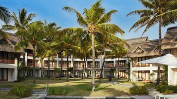 A resort with multiple-story buildings, a swimming pool, and palm trees.