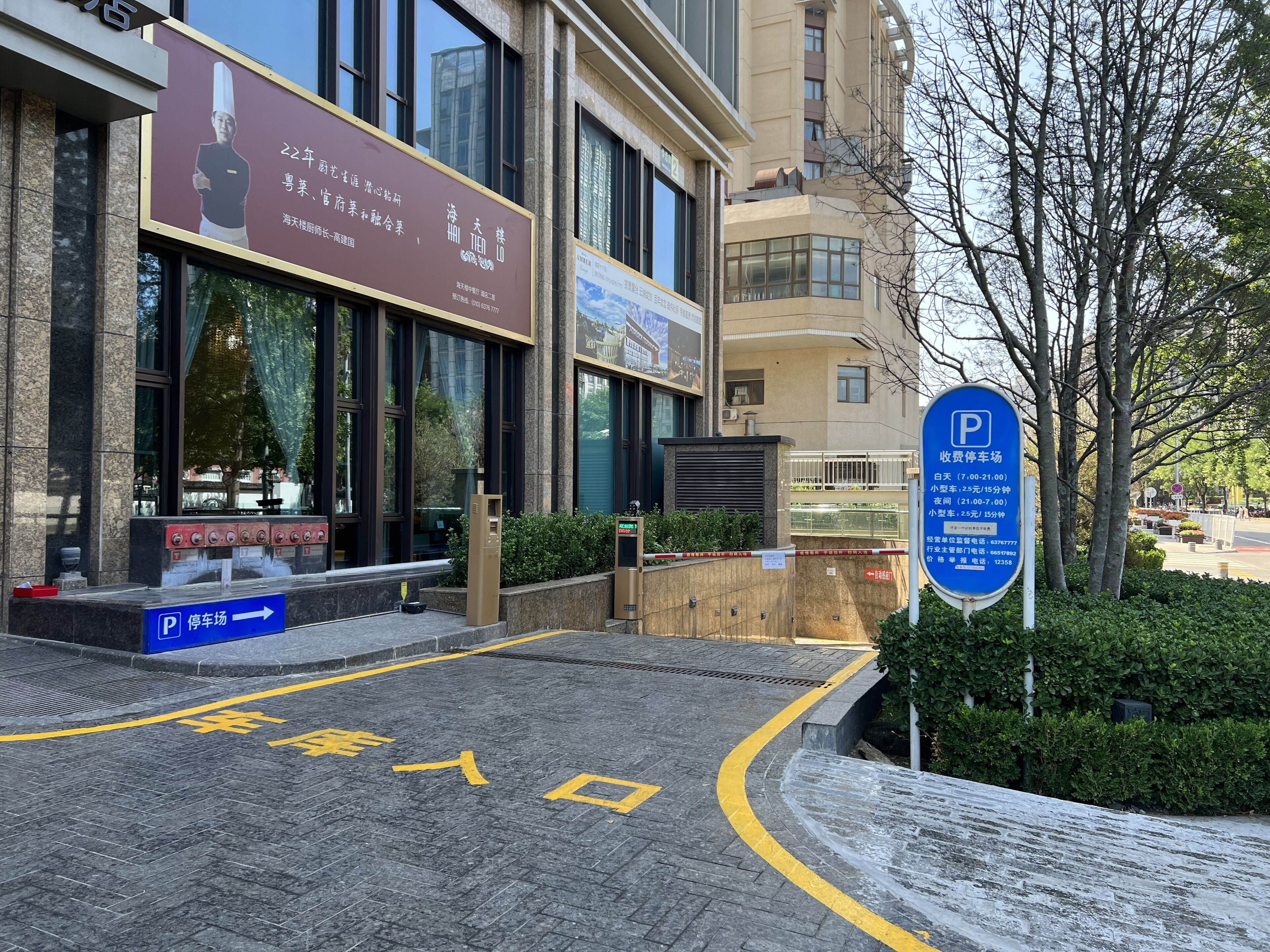 A building with a large signboard, a parking sign, and a clear pathway leading to the entrance.