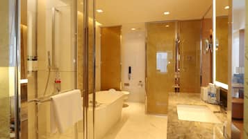 A modern bathroom with a glass-enclosed shower, a freestanding bathtub, and a vanity with a sink.