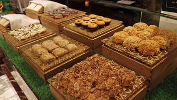 Une variété de produits de boulangerie présentés dans des boîtes en bois, le tout posé sur un sol recouvert d’une moquette verte.
