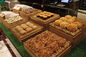 A display of various baked goods in wooden boxes with a green carpeted floor.