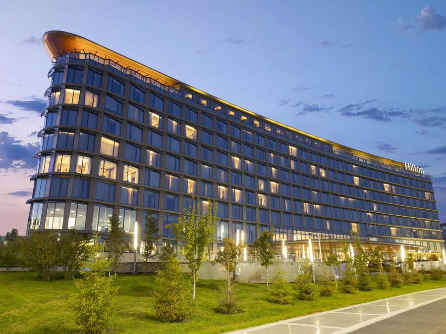 Ein modernes Hotelgebäude mit mehreren Etagen und einem gewölbten Dach.