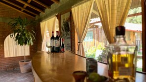 Un área de bar con dos botellas de vino y una botella de licor sobre una encimera de madera.