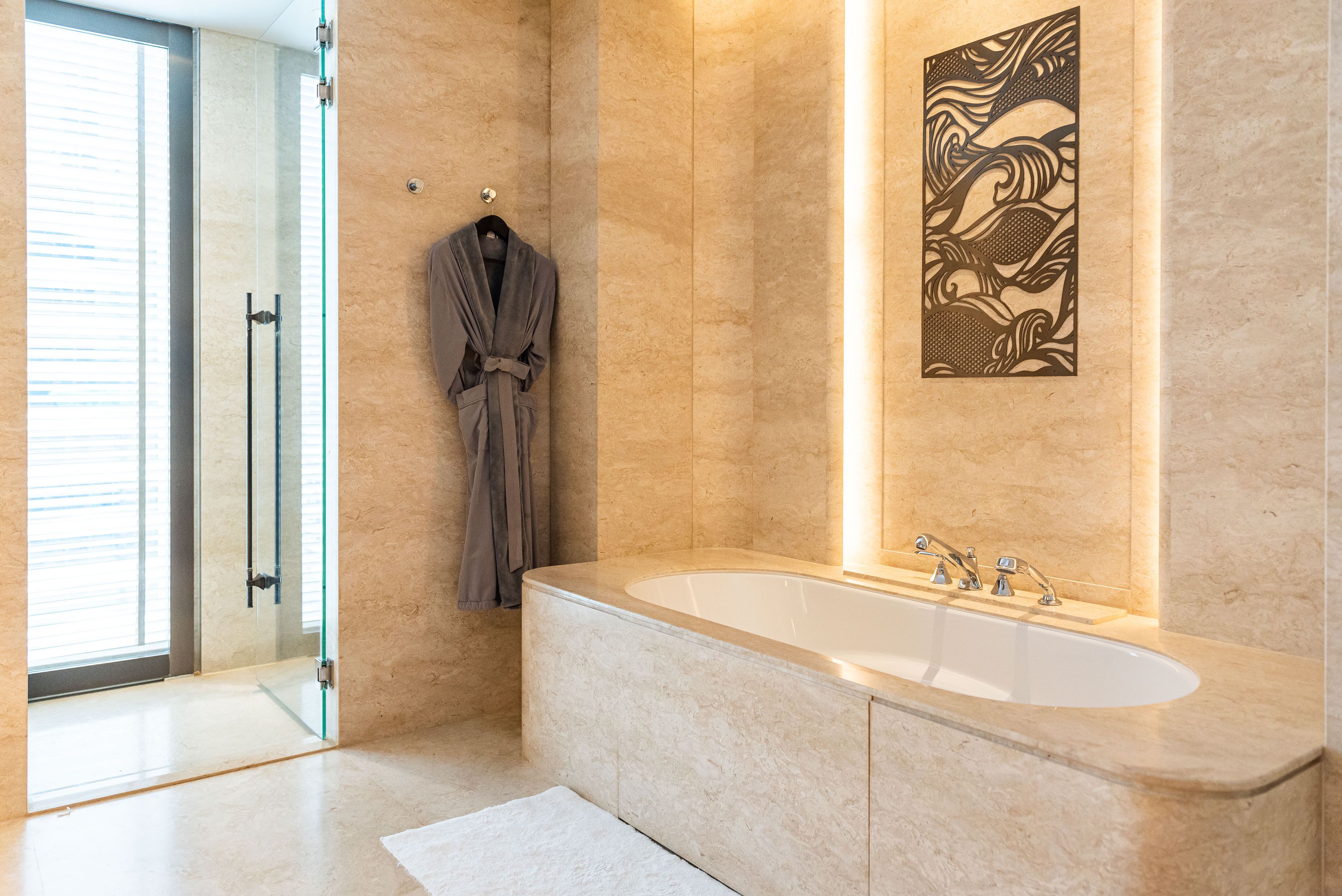 Een moderne badkamer met een groot bad, een douchecabine van glas en een handdoekrek.