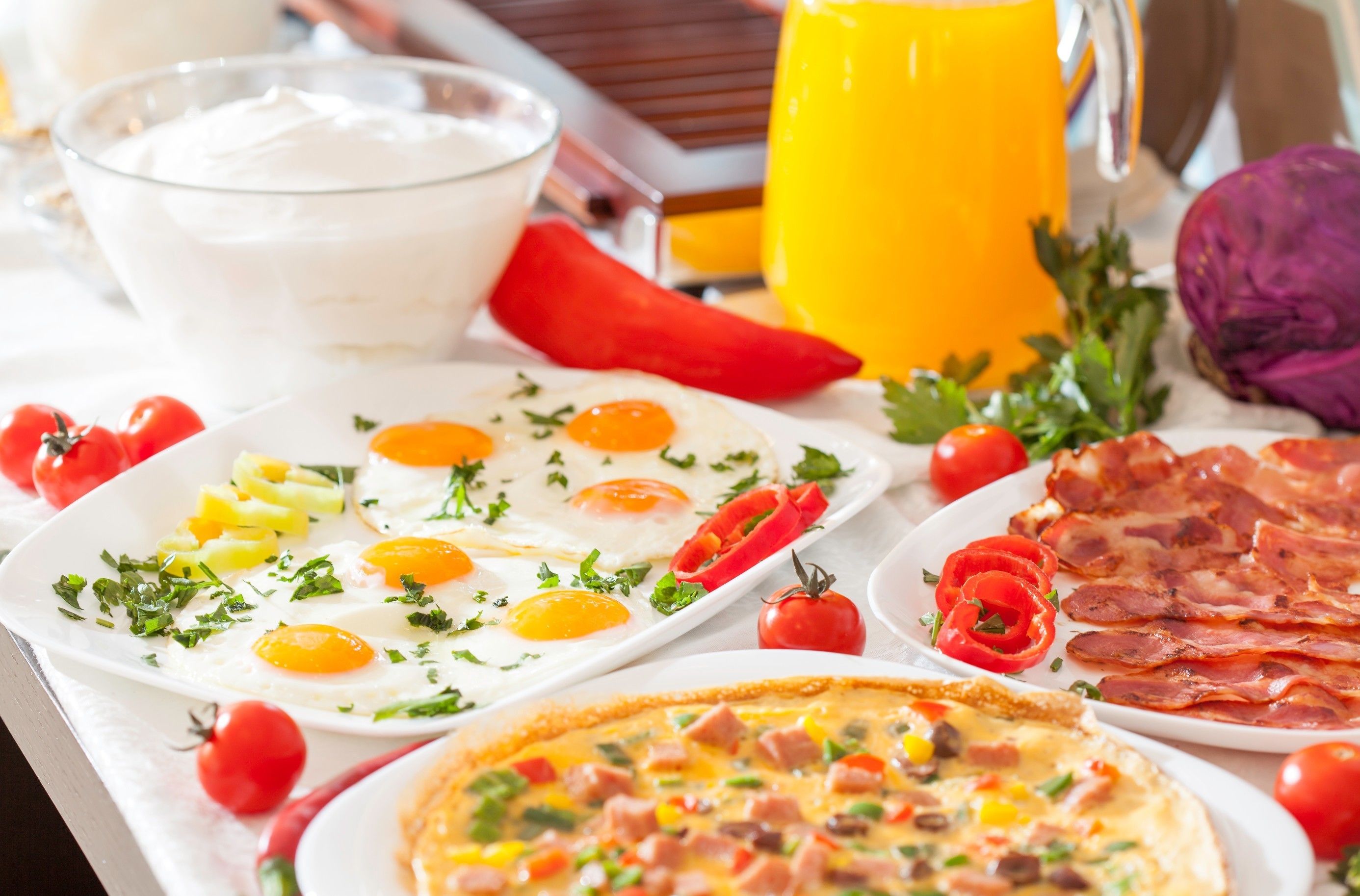 Un buffet de petit-déjeuner proposant divers plats, notamment des œufs, du bacon et une pizza.