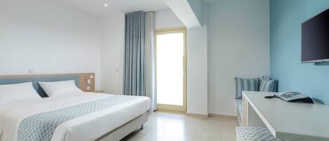 Una habitación de hotel moderna con una cama, un escritorio y un televisor.