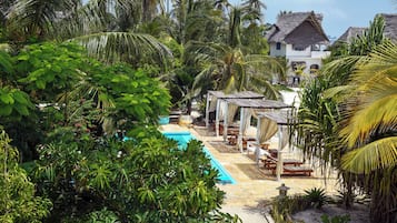 Una piscina al aire libre, sillones reclinables de piscina