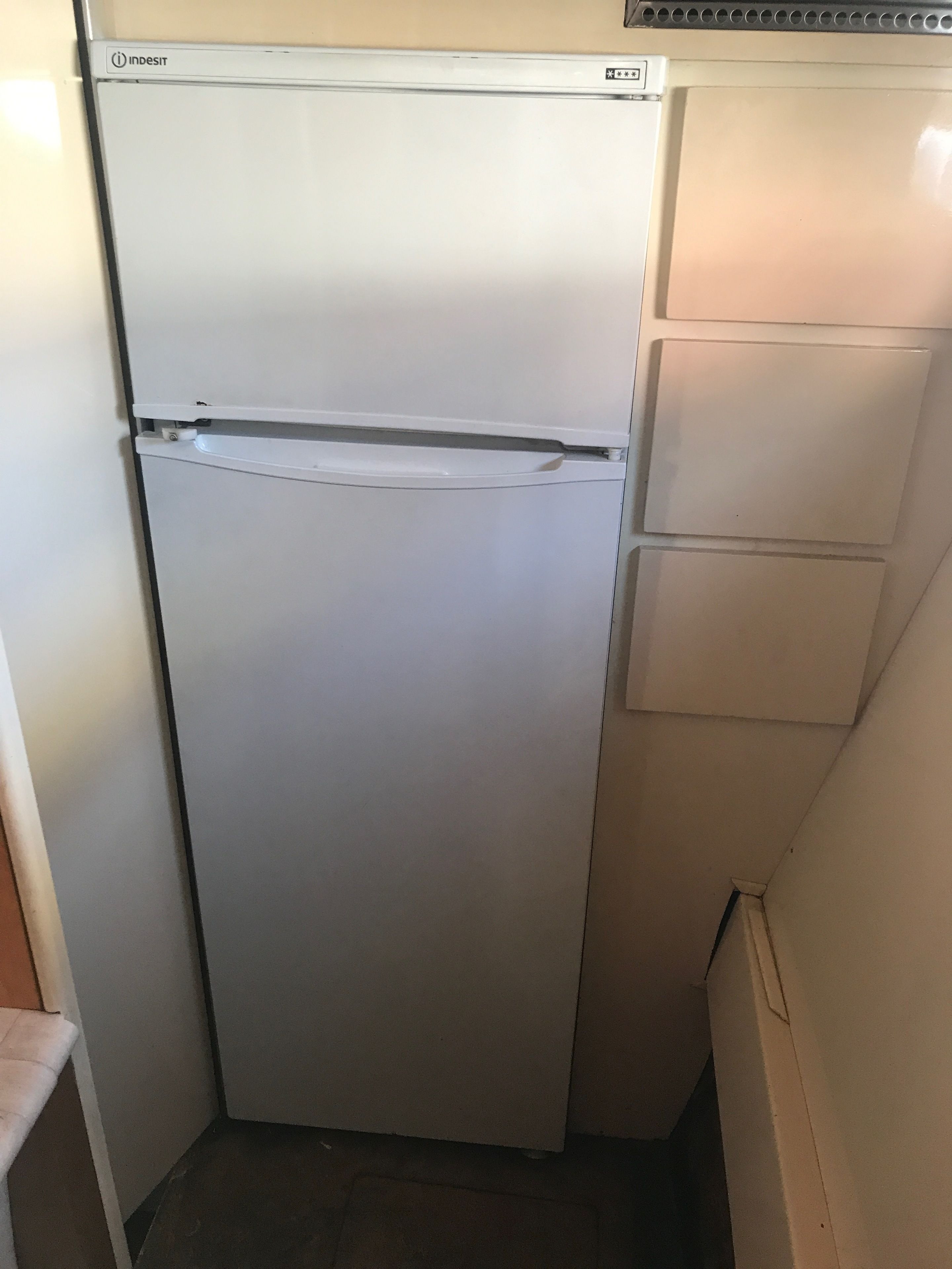 A white refrigerator with a freezer compartment on top and a smaller fridge below.