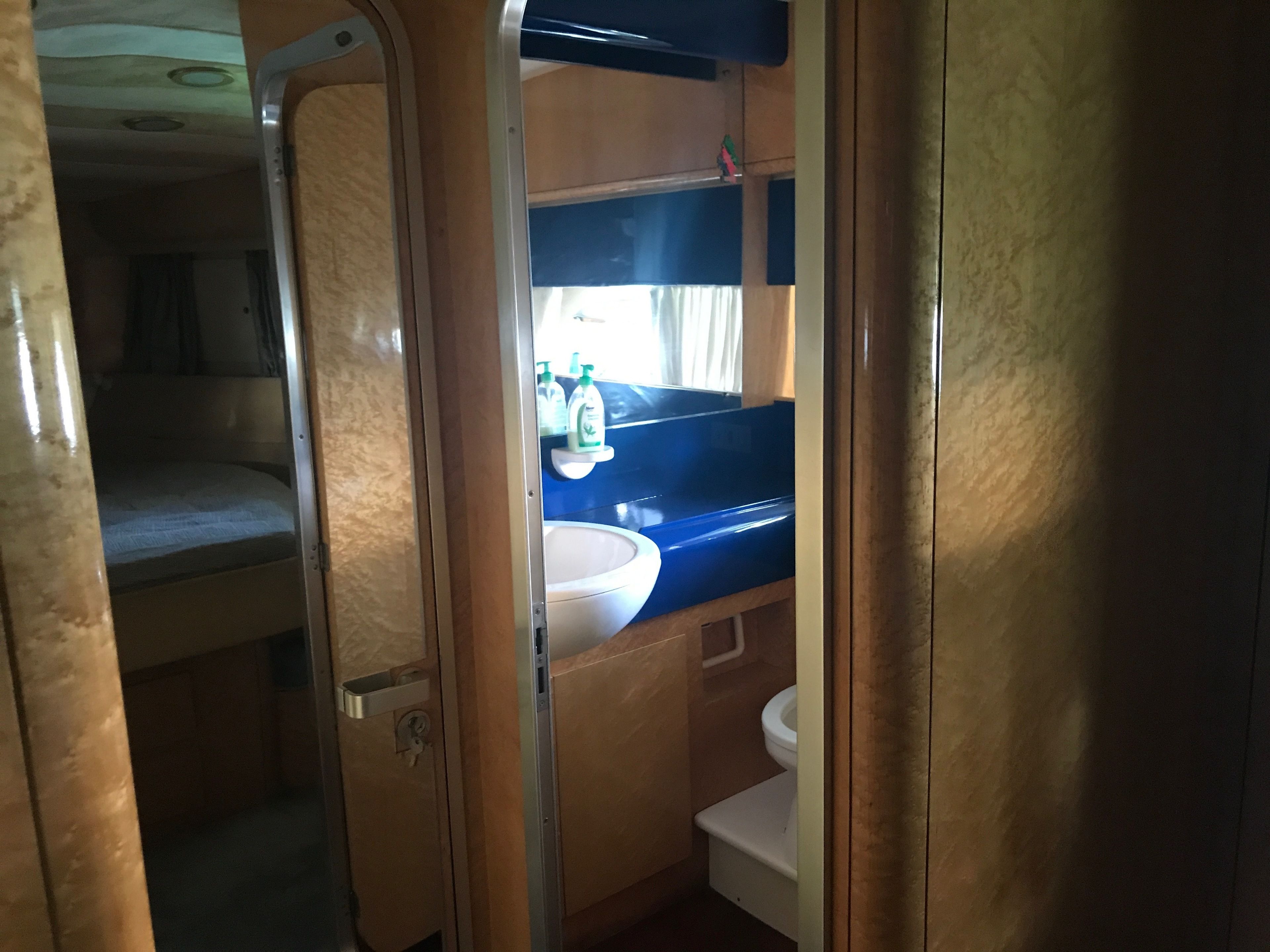 A compact bathroom with a sink, toilet, and a small storage cabinet.