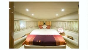 A hotel room with a large bed, curtains, and a nightstand. - Raxul Boat (Villasimius)