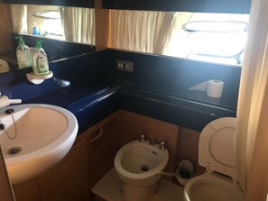 A compact bathroom with a sink, bidet, toilet, and a mirror above the sink. - Raxul Boat (Villasimius)