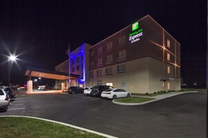 Un hotel Holiday Inn Express & Suites con estacionamiento y entrada techada.
