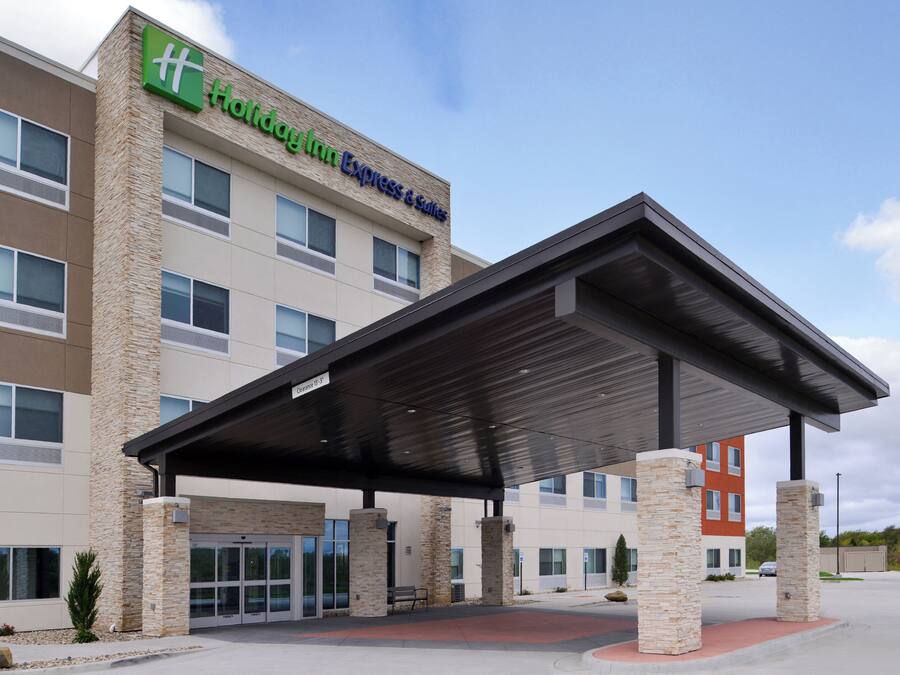 A Holiday Inn Express & Suites building with a covered entrance and stone pillars.