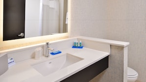 A modern bathroom with a white sink, a mirror, and a toilet. - Holiday Inn Express & Suites Kansas City - Lee's Summit by IHG (Lee's Summit)