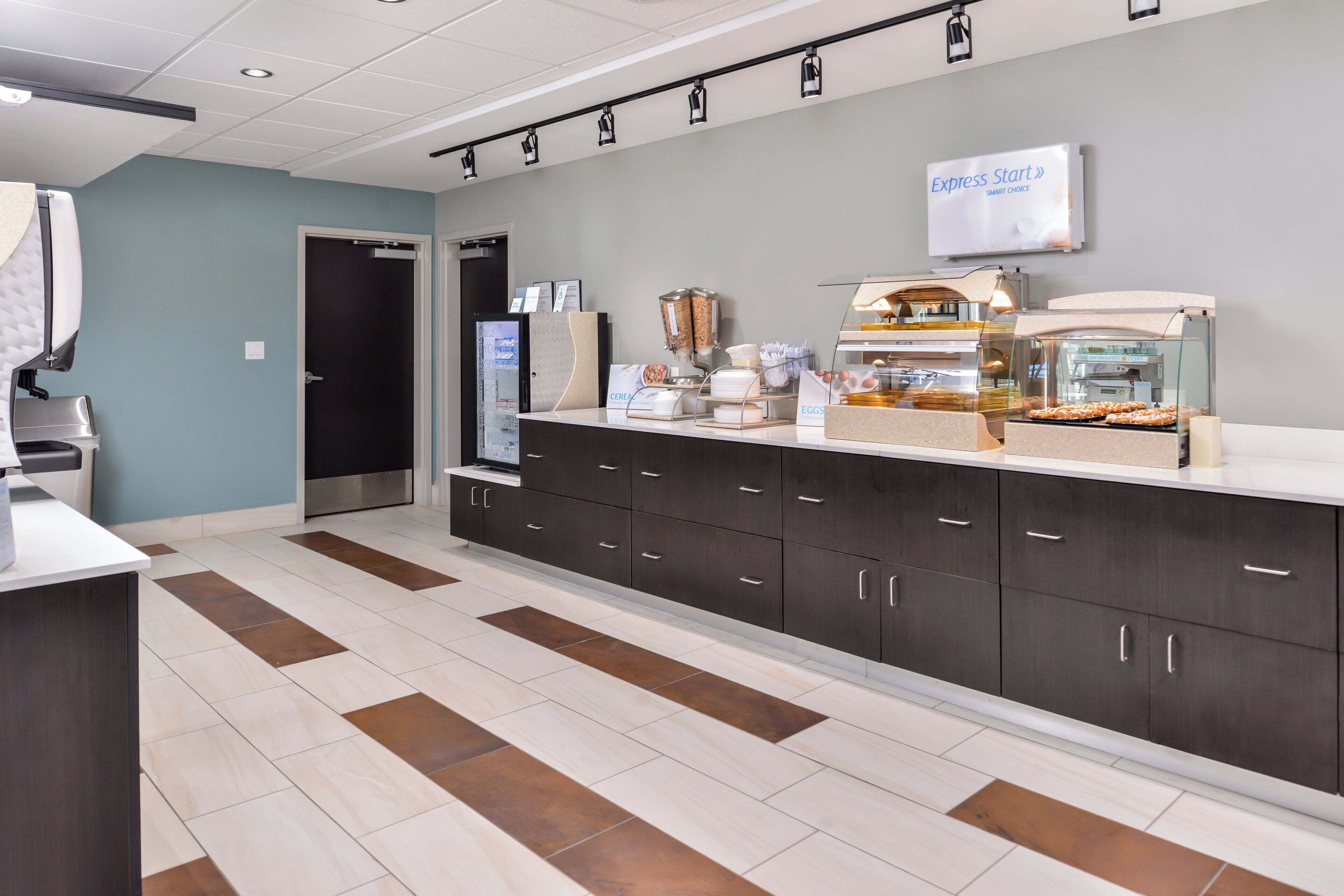 A modern kitchen area with a coffee station, a refrigerator, and a sign indicating 'Express Start'.