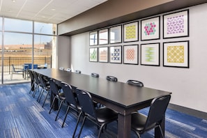A conference room with a long table, chairs, and framed artwork on the wall. - Holiday Inn Express & Suites Kansas City - Lee's Summit by IHG (Lee's Summit)
