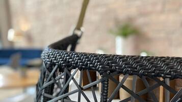 A wicker chair with a woven seat and backrest, supported by a metal frame.