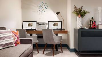 Ein moderner Arbeitsraum mit zwei Schreibtischen, einer Couch und Dekorationselementen.