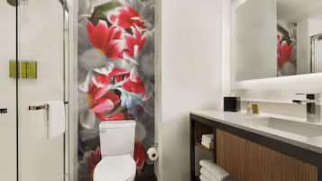 A modern bathroom with a toilet, shower, and sink.