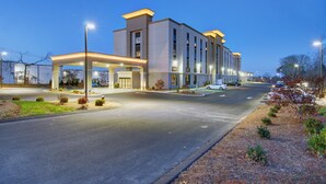 A modern hotel with a spacious entrance, a covered parking area, and a well-lit facade. - Hampton Inn & Suites Boston/Stoughton (Stoughton)