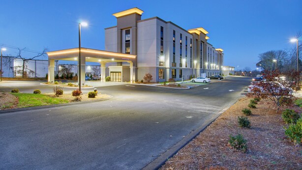 A modern hotel with a spacious entrance, a covered parking area, and a well-lit facade. - Hampton Inn & Suites Boston/Stoughton (Stoughton)