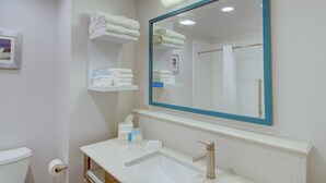 A bathroom with a sink, mirror, and towel rack. - Hampton Inn & Suites Boston/Stoughton (Stoughton)