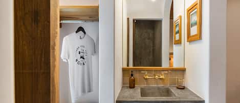 Un bany amb un mirall gran, un lavabo i una barra de tovalloles.