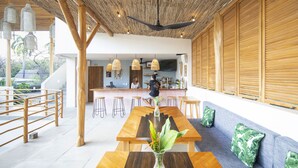 Un interior moderno con techo de madera, zona de bar y diferentes disposiciones de asientos.