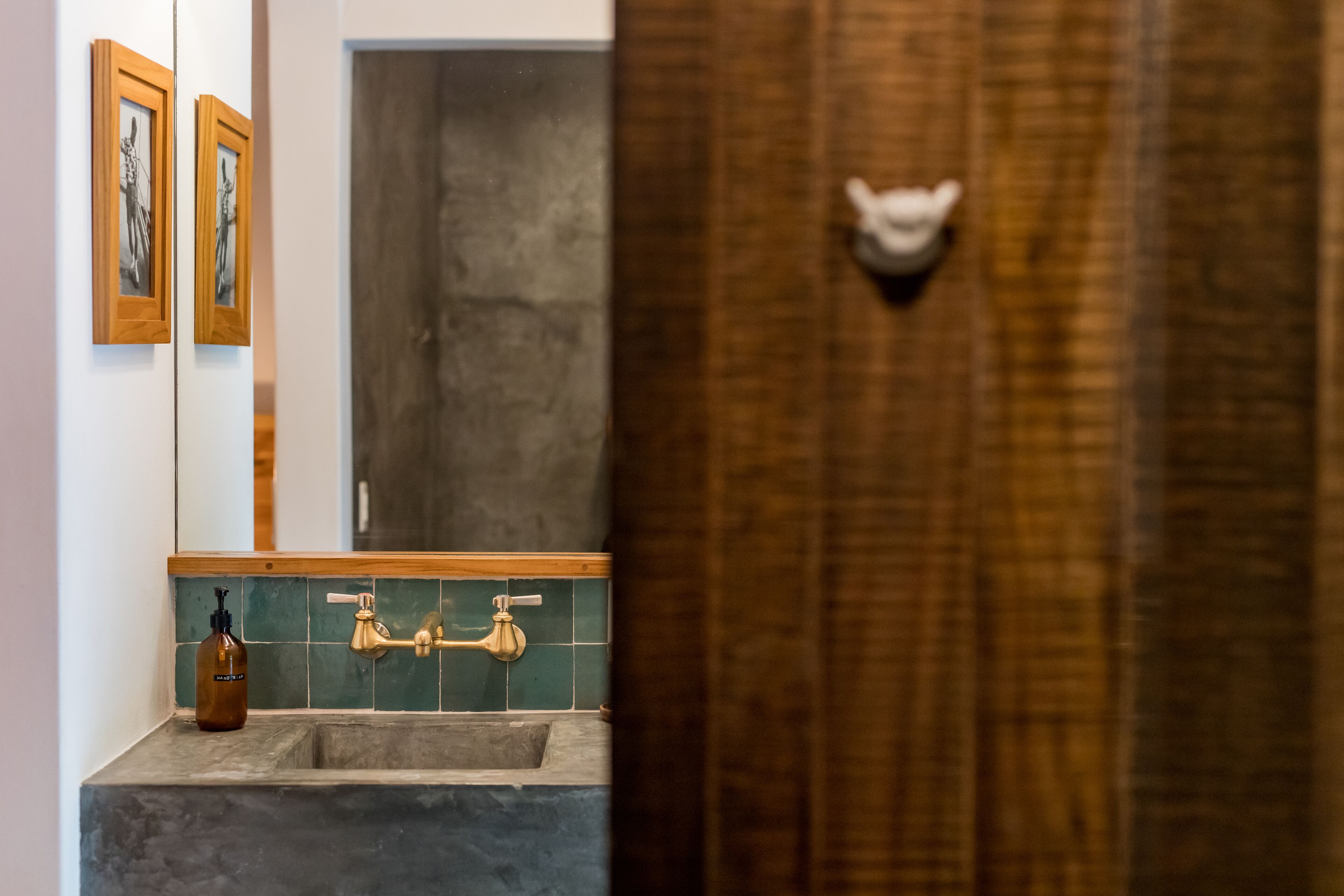 Ein Badezimmer mit Waschbecken, Spiegel und einer Holztür mit weißem Griff.