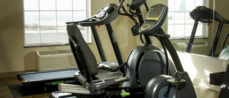 A gym with treadmills, an elliptical, and a stationary bike.