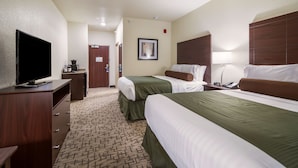 A hotel room with two beds, a television on a dresser, a framed picture on the wall, and a door leading to a bathroom. - Cobblestone Inn & Suites – Soda Springs (Soda Springs)